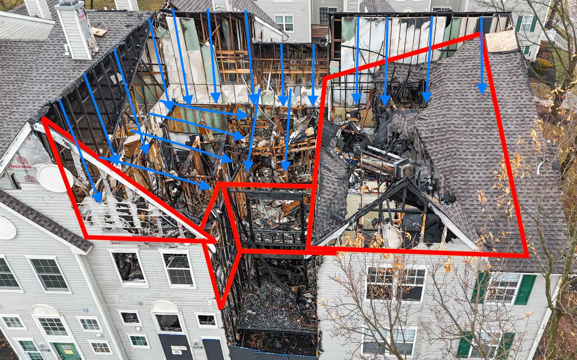 Aerial view of a collapsed multi story home with exposed framing blue arrows show airflow or debris paths and red outlines mark collapsed wall sections and hazard zones
