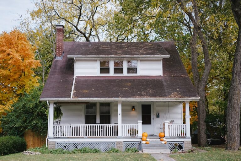 insurance reimbursement storm roof damage commercial 1 StormWrappers StormWrappers White wooden house with a large front porch and pumpkins on the steps autumn trees in the yard